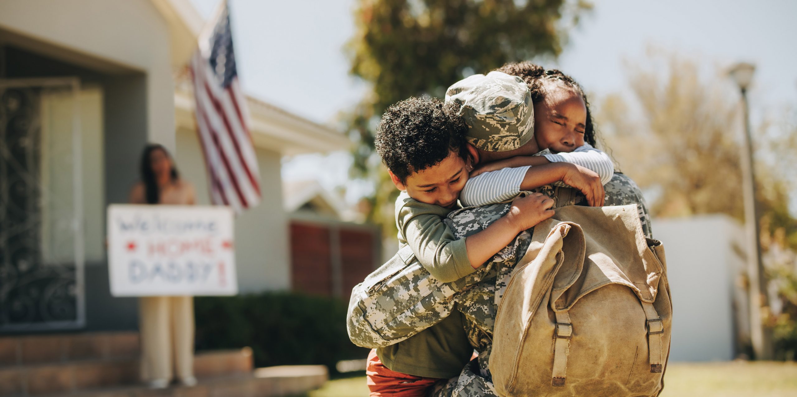 kids hugging military father as he comes home